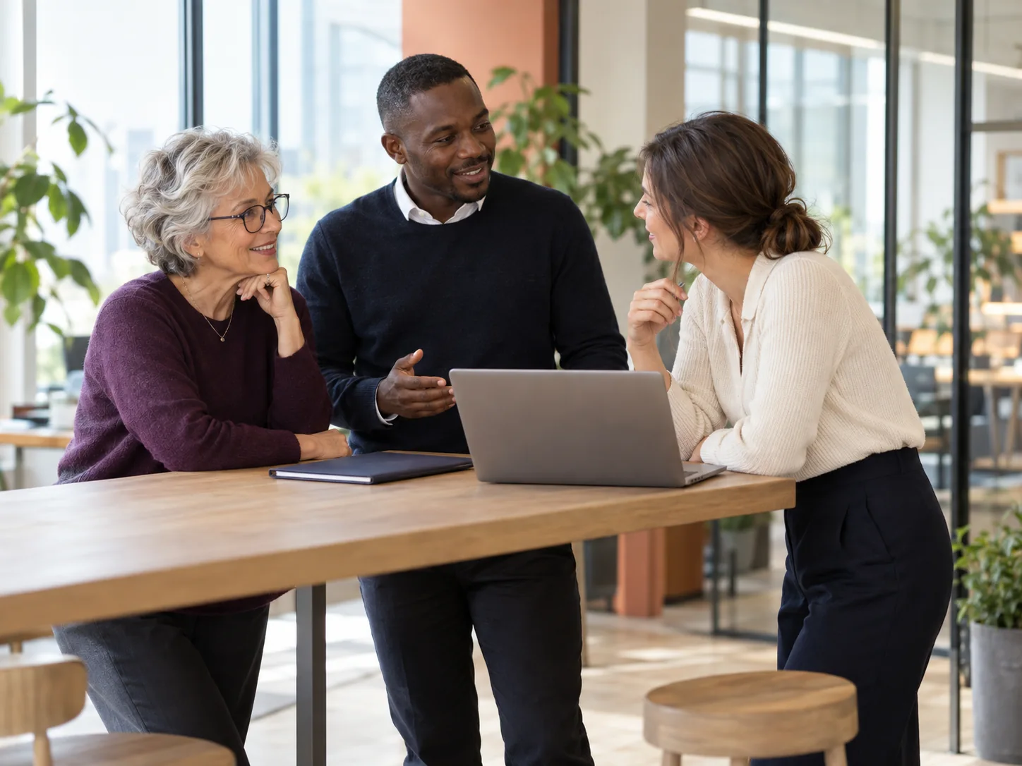 Sfeerbeeld van drie collega’s die samen overleggen aan een werktafel