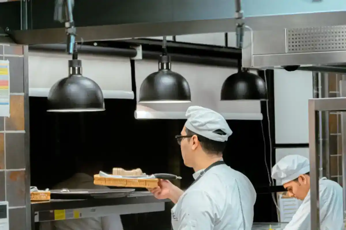 Twee koks bereiden eten in een professionele keuken.