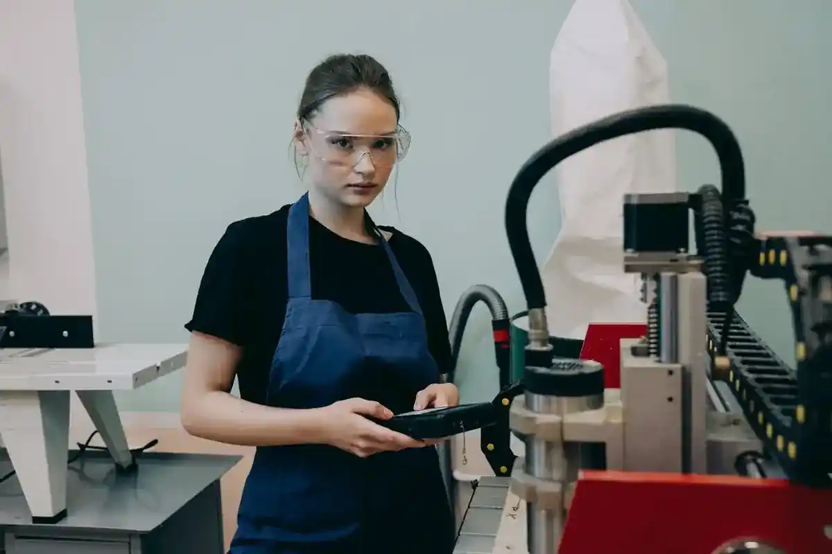 Medewerker met veiligheidsbril bij een CNC-machine.