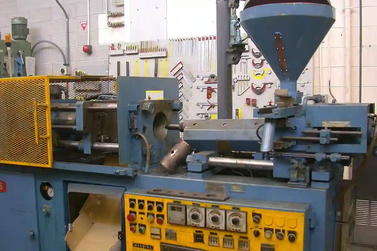 Een spuitgietmachine met materiaalhopper, matrijsruimte en bedieningspaneel.