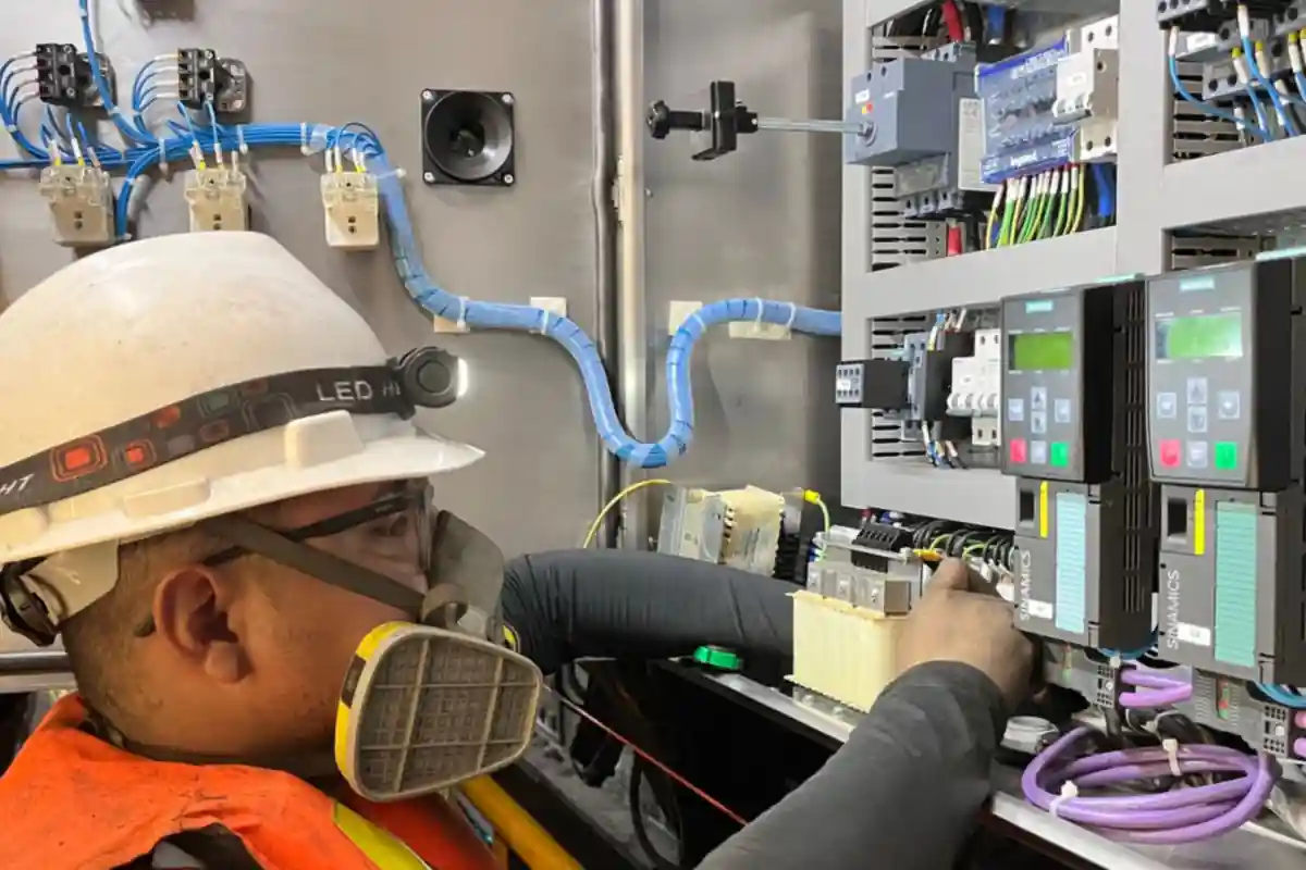 Monteur met helm werkt in een geopende elektrische schakelkast.