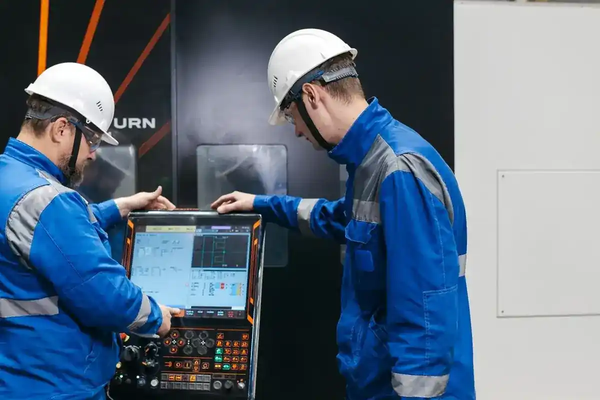 Medewerkers controleren de instellingen van een industriële productiemachine.