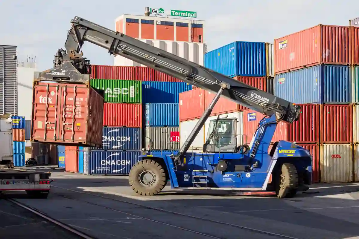 Een reachstacker verplaatst een zeecontainer op een containerterminal.
